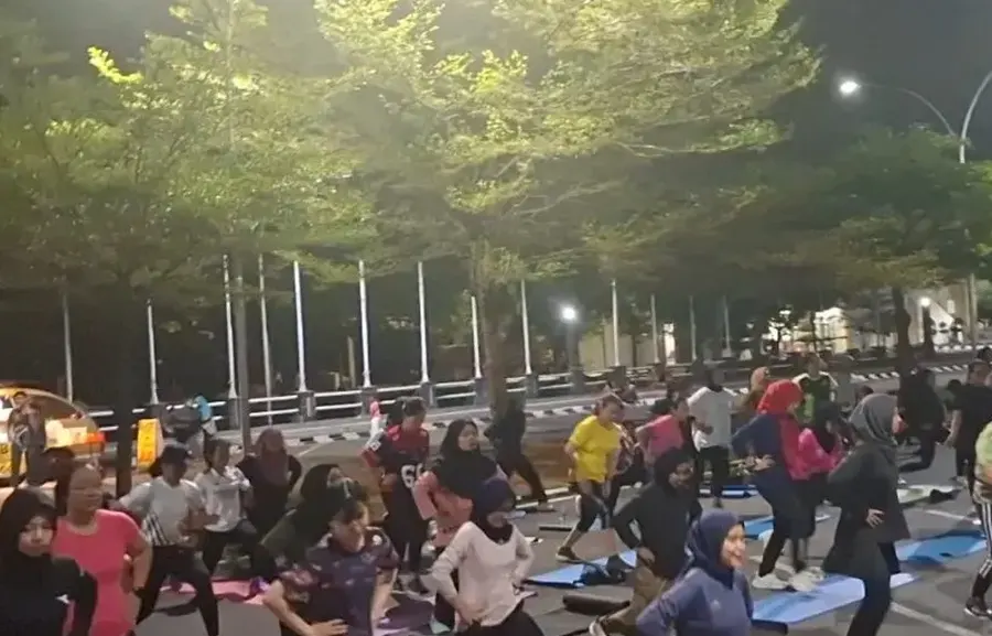 Peserta Sparko Solo melakukan lunges di bawah lampu jalan